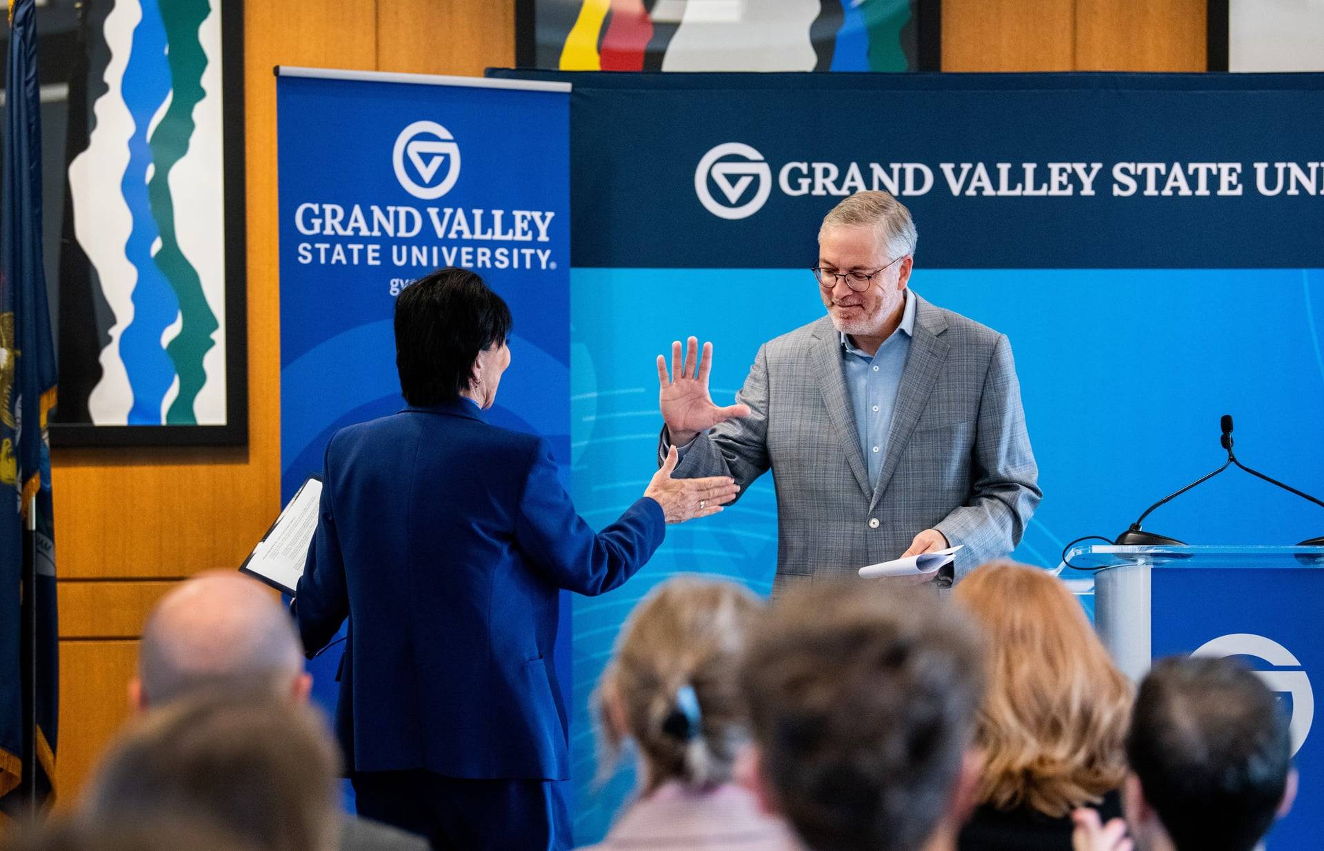 President Mantella gives high five to The Right Place CEO Randy Thelen who is leaving a podium